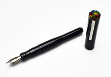 Load image into Gallery viewer, A Franklin-Christoph Model 02 Intrinsic Black Cathedral pen with a #6 nib rests by its marbled acrylic cap top.