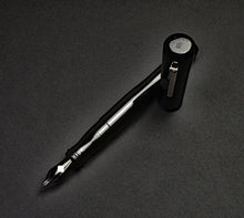 Load image into Gallery viewer, The Franklin-Christoph Model 02 Intrinsic Black Knight with #6 nib and silver clip rests on a dark surface, top view.
