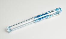 Load image into Gallery viewer, A Franklin-Christoph Model 03 Iterum Arctic Ice &amp; Orchid Blue SE fountain pen lies on a plain white background.