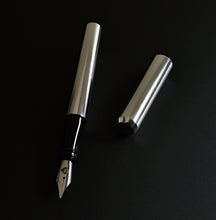 Load image into Gallery viewer, A Franklin-Christoph Model 03 Modified Aluminum fountain pen, uncapped, lies on a black surface.