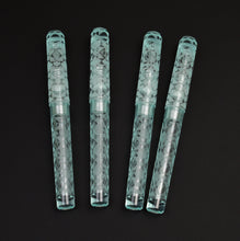 Load image into Gallery viewer, Four light blue Franklin-Christoph pens, including one Model 03M Antique Glass Abstract Diamond, on a black background.