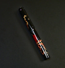 Load image into Gallery viewer, A Franklin-Christoph Model 03M Eel vs Octopus pen with gold, red, and orange maki-e details rests on a dark surface.