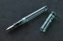 Load image into Gallery viewer, A Franklin-Christoph Model 03 Modified Fountain Pen - Antique Glass SE lies uncapped on a textured dark gray surface.