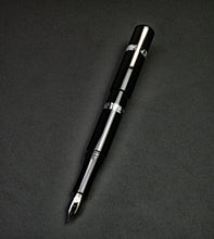Load image into Gallery viewer, Franklin-Christoph Model 19 Fountain Pen - Black &amp; Dark Room Emulsion rests diagonally on a dark, textured background.