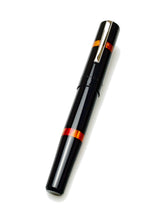 Load image into Gallery viewer, Franklin-Christoph Model 19 Fountain Pen - Black Fire SE with red-orange bands and silver clip on white background.