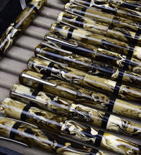 Load image into Gallery viewer, Franklin-Christoph Model 19 Cold Brew SE fountain pens with marbled yellow, black &amp; white finishes displayed in a tray.