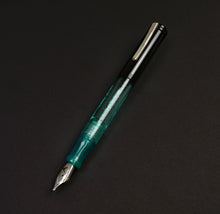 Load image into Gallery viewer, A Franklin-Christoph Model 20 Black Sea Glass Andromeda SE fountain pen sits on a plain black surface.