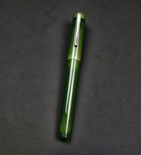 Load image into Gallery viewer, The Franklin-Christoph Model 20 Marietta Fountain Pen - Jade with silver clip lies on a dark, textured surface.