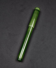 Load image into Gallery viewer, A Franklin-Christoph Model 20 Marietta Fountain Pen in Jade rests diagonally on a black textured surface, capped.