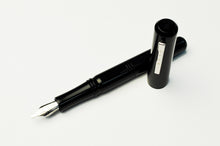 Load image into Gallery viewer, The Franklin-Christoph Model 31 Omnis Fountain Pen in Classic Black with a silver nib rests beside its cap.