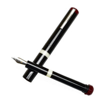 Load image into Gallery viewer, The Franklin-Christoph Model 33 Abditus Fountain Pen, black with white bands and silver nib, uncapped with cap beside.