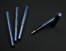Load image into Gallery viewer, Four Franklin-Christoph Model 40 Panther Indigo Black SE fountain pens, three capped, one uncapped, on black background.