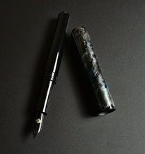 Load image into Gallery viewer, The Franklin-Christoph 40M SCF Art Silver-Blue Fountain Pen with a marbled cap rests on a textured surface.