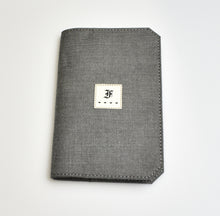 Load image into Gallery viewer, A gray fabric 5.3 Pocket Notebook Cover by Franklin-Christoph, with a white F patch and four black stars below it.