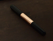 Load image into Gallery viewer, Franklin-Christoph Model 55 Pentium FP - Black Copper SE pen rests on a dark brown, subtly embossed surface.