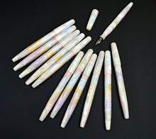 Load image into Gallery viewer, Twelve Franklin-Christoph Model 66 Opal pens and one uncapped pen, arranged on a black background.