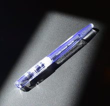 Load image into Gallery viewer, The Franklin-Christoph Model 66 Septagonal Italian Ice fountain pen glows on a dark, textured surface under bright light.
