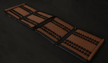 Load image into Gallery viewer, The Franklin-Christoph 80 Pen Case in brown and black leather, unzipped and laid flat on a dark surface.