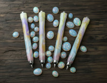 Load image into Gallery viewer, Four pastel pens and a Franklin-Christoph Model 91 Graphis Mechanical Pencil - Opal SE rest on dark wood with opal stones.