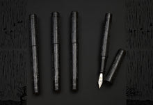 Load image into Gallery viewer, One Franklin-Christoph Delrin Model 03M pen is uncapped among four, displayed on a black patterned backdrop.