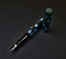 Load image into Gallery viewer, Franklin-Christoph 03M A. A. Vacharat Street Deluge pen, blue-black marbled, uncapped on a dark surface.