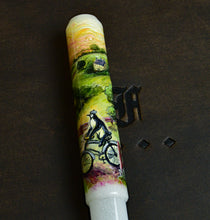 Load image into Gallery viewer, Franklin-Christoph 40 M pen with A.A. Vacharat’s Bicycle Penguin art: a biker rides through greenery to a house.
