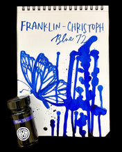 Load image into Gallery viewer, A sketchbook shows blue butterfly art with Franklin-Christoph Bottled Ink and its matching fountain pen ink bottle.