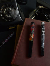 Load image into Gallery viewer, Two Franklin-Christoph 40M pens sit on a book, with camera and phone, in Germantown, Philadelphia.