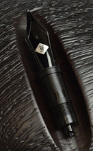 Load image into Gallery viewer, A Franklin-Christoph #6 Nib Unit rests on dark brown wood, echoing the look of premium gold fountain pen nibs.