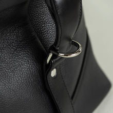 Load image into Gallery viewer, Close-up of Franklin-Christoph Duffle Bag - Black Leather with silver ring, perfect for a luxe weekend getaway.