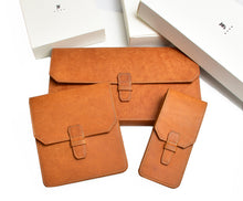 Load image into Gallery viewer, Three Franklin-Christoph Penvelope 12 Italian leather pouches sit before white boxes on a white background.
