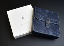 Load image into Gallery viewer, A Franklin-Christoph New Penvelope 6 NWF in navy blue with white stitching rests beside its box on a black surface.