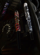 Load image into Gallery viewer, Three Franklin-Christoph pens, including the 03M City Rain, rest on a vintage rotary phone with dial numbers showing.