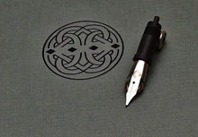 Load image into Gallery viewer, A Franklin-Christoph HPSteel S.I.G. FLEX nib with ebonite feed lies on a textured surface, near a black pattern.