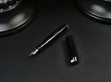 Load image into Gallery viewer, pocket 45 fountain pen with Onyx acrylic and smoke finials. One pen uncapped dark background with bases of lamps showing.