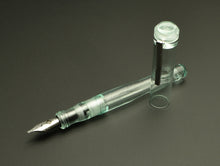 Load image into Gallery viewer, The Franklin-Christoph Model 02 Antique Glass SE, its cap off, rests on a dark surface showing its #6 silver nib.