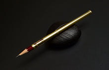 Load image into Gallery viewer, A Franklin-Christoph Solid Gold 18K Pencil Extender rests on smooth black stone against a dark background.