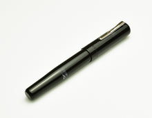 Load image into Gallery viewer, A Franklin-Christoph Model 19 Fountain Pen - Black &amp; Smoke with #6 nib and silver clip rests on a white surface.