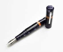 Load image into Gallery viewer, A Franklin-Christoph Model 19 Smokey Orange SE fountain pen with #6 nib lies uncapped beside its cap on white.