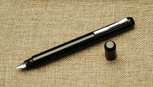 Load image into Gallery viewer, Franklin-Christoph Model 25 Eclipse Fountain Pen - Classic Black with nib rests on textured brown fabric.