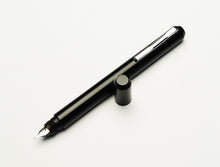 Load image into Gallery viewer, The Franklin-Christoph Model 25 Eclipse Fountain Pen rests uncapped, nib down, on a white background.