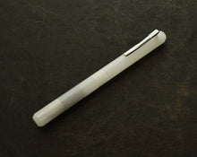 Load image into Gallery viewer, Franklin-Christoph Model 25 Eclipse “Ghost” fountain pen with silver clip rests diagonally on dark brown textured surface.
