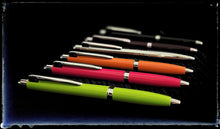 Load image into Gallery viewer, Eight Franklin-Christoph Model 28 Shortstock Ballpoints, in electric lime and more, on a dark textured background.