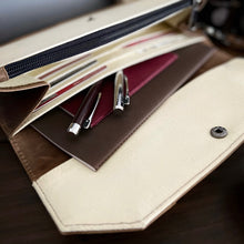 Load image into Gallery viewer, Cream wallet open, showing Franklin-Christoph Model 28 Shortstock Ballpoint (Maroon), envelopes, and cards on dark surface.