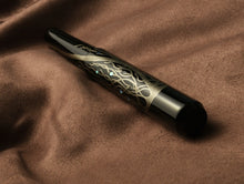 Load image into Gallery viewer, Franklin-Christoph Model 40 Panther Diamondtree LE FP rests on soft brown fabric, black and gold with intricate design.