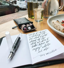 Load image into Gallery viewer, Open Franklin-Christoph 5.3 Pocket Notebook Refill—64 pages—on table with pen, glasses case, meal &amp; handwritten quote.