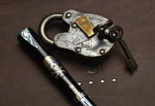 Load image into Gallery viewer, A vintage padlock with key rests beside a Franklin-Christoph Model 50 Outer Banks LE fountain pen adorned with skulls.