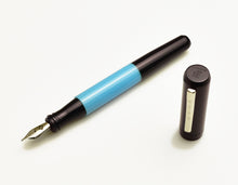 Load image into Gallery viewer, A Franklin-Christoph Model 55 Pentium Midnight Sky Blue SE fountain pen with its cap beside it, featuring a #5 nib.
