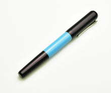 Load image into Gallery viewer, A Franklin-Christoph Model 55 Pentium Midnight Sky Blue SE fountain pen with a silver clip rests on a white surface.