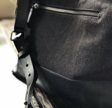 Load image into Gallery viewer, Close-up of the Franklin-Christoph Fortis Sling Bag in Iron Brown/Black, water-repellent with leather strap and zip pocket.